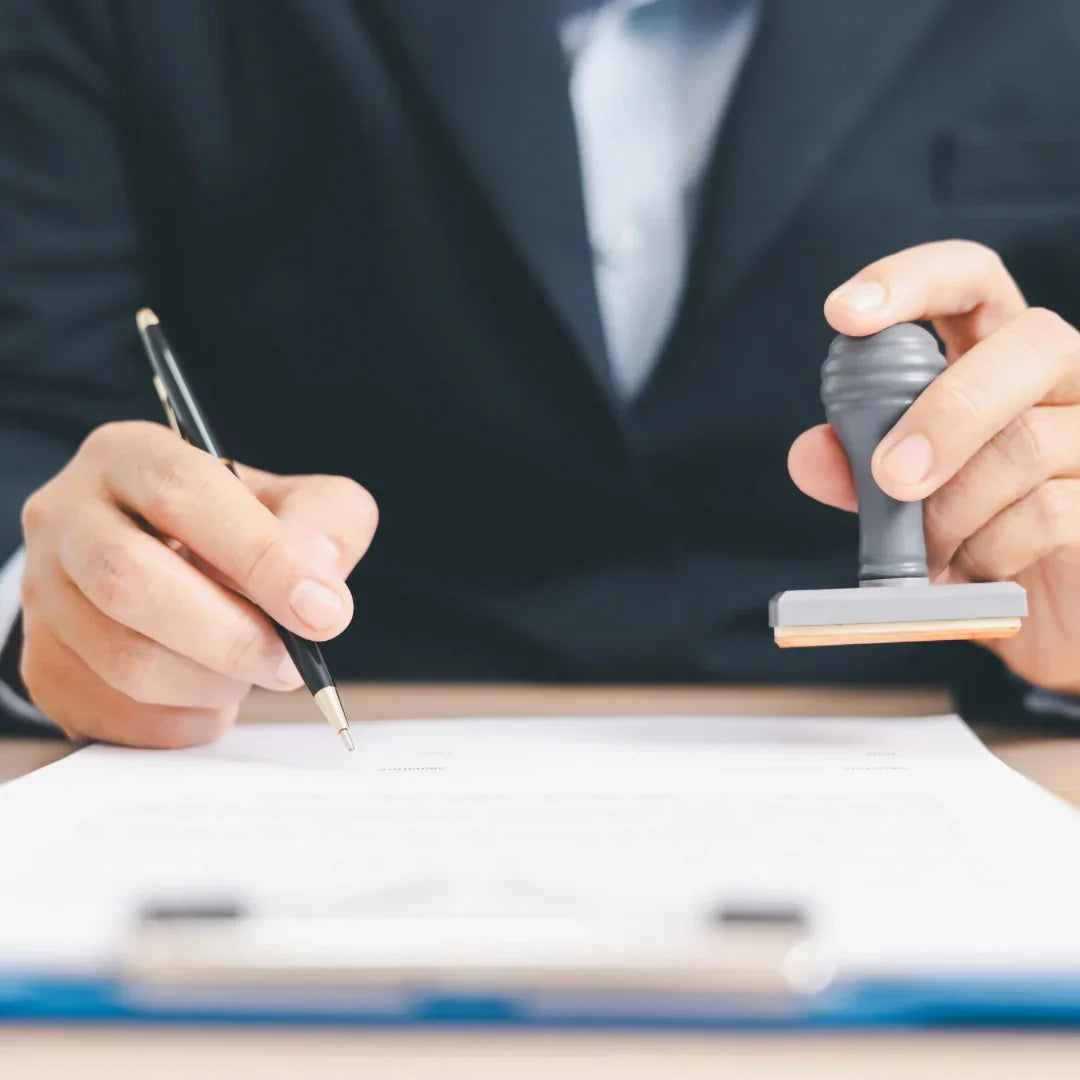 Homme en costume tamponnant un document de traduction assermentée officielle