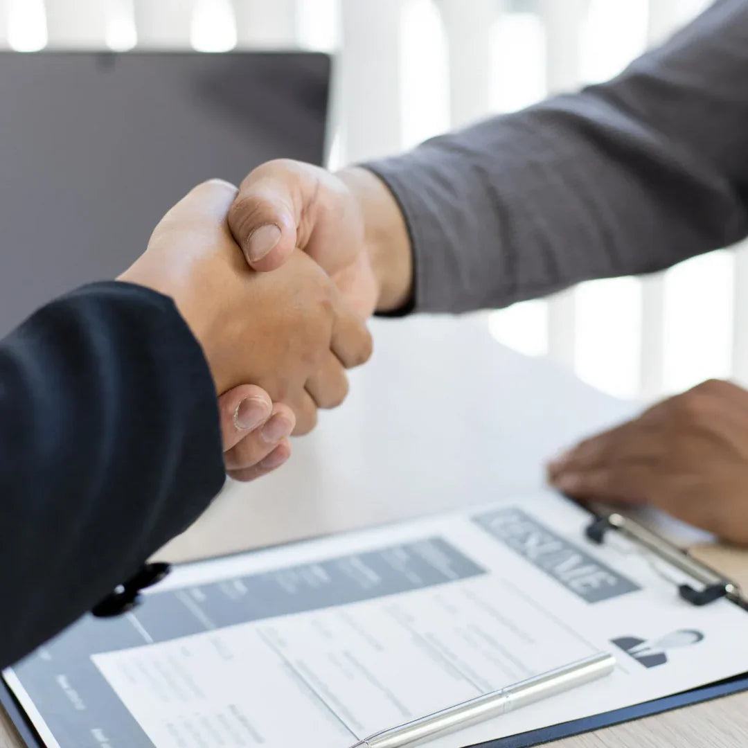 Poignée de main professionnelle devant un CV, entretien d'embauche, traduction certifiée