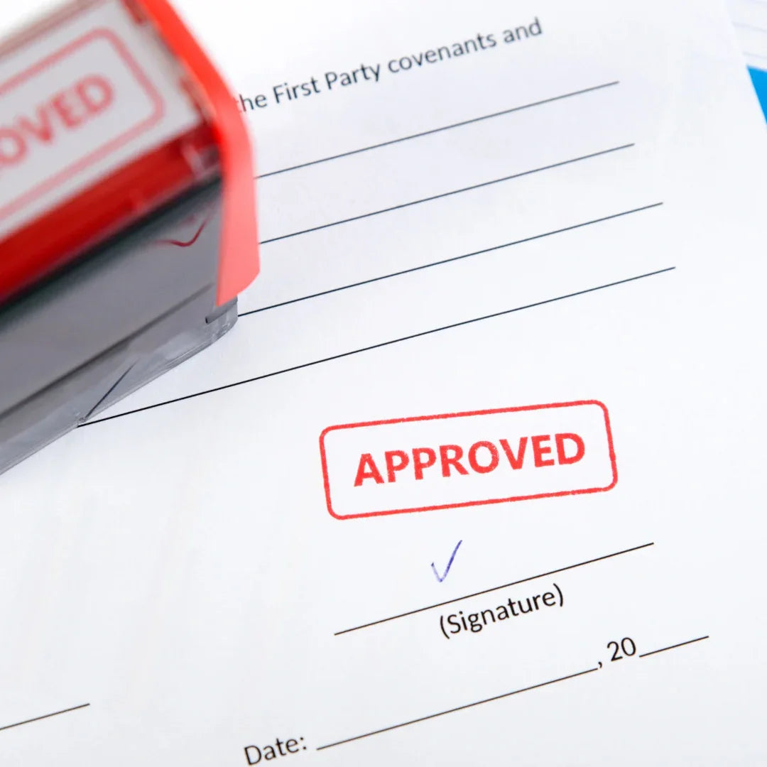 Tampon rouge marqué APPROVED sur document officiel prêt à être signé